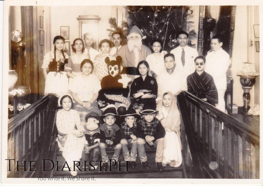 A Christmas costume party in the old house, with the big Christmas tree on top of the staircase. (First row, from left) Julia Napil Casas, Nakpil and Tapales nephews (Second row, from left) Anita Noble Nakpil (wife of Juan), Mickey Mouse, Josefina Nakpil Tapales, Juan Nakpil, man with sunglasses unknown (Third row, from left) Antonia Nakpil Escaler (cousin of Julio's children), Anita de Lange (sister-in-law of Francisca), Mercedes Nakpil Zialcita, Santa Claus, author’s mother Caridad Nakpil Santos-Viola, and other male personalities.
